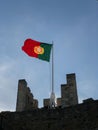 Vertical shot of the Portuguese flag waving on Saint George's Castle in Lisbon, Portugal Royalty Free Stock Photo