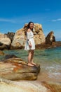 Vertical shot of a pretty Asian girl standing on rocks near the blue ocean in Vietnam Royalty Free Stock Photo