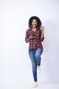 Vertical shot of a pretty black female feeling excited while using her phone Royalty Free Stock Photo