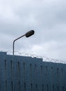 Vertical shot of the prison wall with high security fence Royalty Free Stock Photo