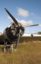 Vertical shot of the propeller of a plane landed on the dry grass Royalty Free Stock Photo