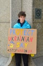 Vertical shot of a protestor holding a banner show solidarity for Ukraine