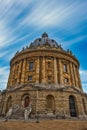 Vertical shot of Radcliffe Camera library on blue cloudy sky background in Oxford, England Royalty Free Stock Photo
