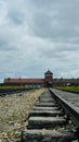 Vertical shot of railways leading to an old brick building on a cloudy day