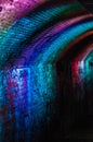 Vertical shot of random paintings on a tunnel wall with LED lights Royalty Free Stock Photo