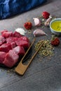 Vertical shot of raw cut meat, garlic cloves, dried pepper, oil on the table - making dinner