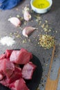 Vertical shot of raw cut meat, garlic cloves, oil on the table - making dinner Royalty Free Stock Photo