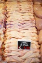 Vertical shot of raw fresh chicken meat slices on a display of a market counter with a price tag Royalty Free Stock Photo