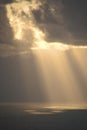 Vertical shot of rays of sun shining through clouds Royalty Free Stock Photo
