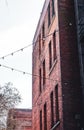 Vertical shot of red brick apartment building with hanging lights in Seattle, Wahington