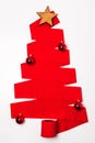 Vertical shot of a red Christmas tree made from a toilet paper roll with ornaments under the lights Royalty Free Stock Photo