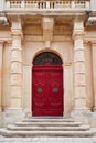 Vertical shot of a red door of a building in Mdina, Malta Royalty Free Stock Photo