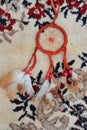 Vertical shot of a red dream catcher lying on a carpet