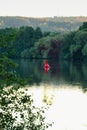 Vertical shot of the red kayak sailing in river