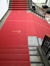 Vertical shot of a red stairway with the direction marked on the ground Royalty Free Stock Photo