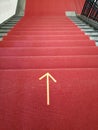 Vertical shot of a red stairway with the direction marked on the ground Royalty Free Stock Photo