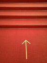 Vertical shot of a red stairway with the direction marked on the ground Royalty Free Stock Photo