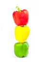 Vertical shot of red, yellow and green bell peppers on each other forming a traffic light Royalty Free Stock Photo