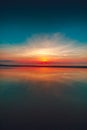 Vertical shot of the reflection of the sunset on the beach captured in Vrouwenpolder, Netherlands