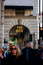 Vertical shot of the Ritz hotel with a bustling crowd passing by in London, UK