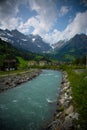 Vertical shot of a river in the countryside surrounded by a wild landscape Royalty Free Stock Photo