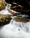 Vertical shot of a river flowing over rocks with long exposure Royalty Free Stock Photo