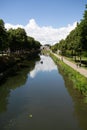 Vertical shot of a river flowing through a park in Amiens, France