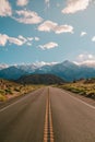 Vertical shot of a road with the magnificent mountains under the blue sky captured in California Royalty Free Stock Photo
