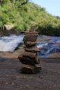 Vertical shot of rock balancing on the river shore in a forest Royalty Free Stock Photo