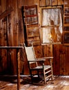 Vertical shot of a rocking chair near a broken wooden window Royalty Free Stock Photo