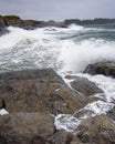 Vertical shot of rocks surrounded by the sea under a cloudy sky on a gloomy day Royalty Free Stock Photo