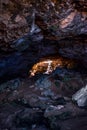 Vertical shot of rocky cave with a big hole and a wooden ladder- perfect for old mines concept Royalty Free Stock Photo