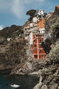 Vertical shot of a rocky cliff and the village of Riomaggiore, Cinque Terre, Italy Royalty Free Stock Photo