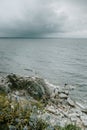 Vertical shot of a rocky shore and the blue sea on a cloudy day Royalty Free Stock Photo