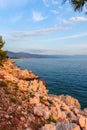 Vertical shot of a rocky shoreline of a lake with mountains visible on the horizon Royalty Free Stock Photo