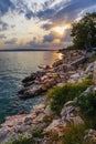 Vertical shot of a rocky shoreline of a lake seen during the sunset Royalty Free Stock Photo