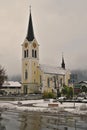 Vertical shot of a Roman Catholic church in Riezlern, Kleinwalsertal Austria in the winter Royalty Free Stock Photo