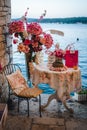 Vertical shot of a romantic cafe table at the shore in a narrow street in Rovinj, Croatia