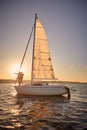 Vertical shot of a romantic senior couple enjoying enjoying amazing sunset sunset while standing on the side of sail