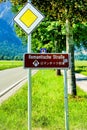 Vertical shot of the romantische Strasse sign on the side of the road