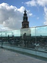 Vertical shot of a rooftop with a glass protection with the view of Martinitoren church tower