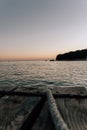 Vertical shot of a rope on a wooden pier on a sunset background Royalty Free Stock Photo