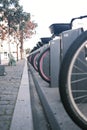 Vertical shot of the row of bicycles parked in a bike stand on the street. Royalty Free Stock Photo