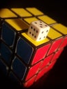 Vertical shot of Rubik's cube and white dice on top isolated on a black background Royalty Free Stock Photo