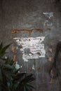 Vertical shot of a rustic, weathered paper post on a wall