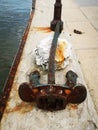 Vertical shot of a rusty anchor along the coast Royalty Free Stock Photo