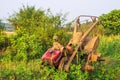 Vertical shot of rusty farm equipment in an abandoned field under the light Royalty Free Stock Photo