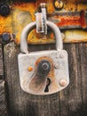 Vertical shot of a rusty frosted padlock was used to lock old wooden door Royalty Free Stock Photo