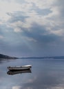 Vertical shot of a rusty white boat in the sea reflecting on the water surface Royalty Free Stock Photo