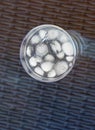 Vertical shot of s glass of ice water on a glass table on the balcony of the house Royalty Free Stock Photo